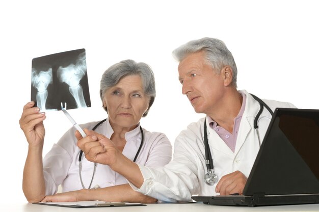 Elderly doctors with a laptop and x-ray on a white