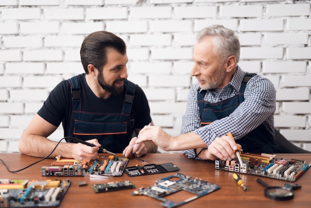 Foto anziano padre e figlio fanno riparazione del computer.