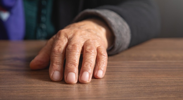 Elderly female hand on the table