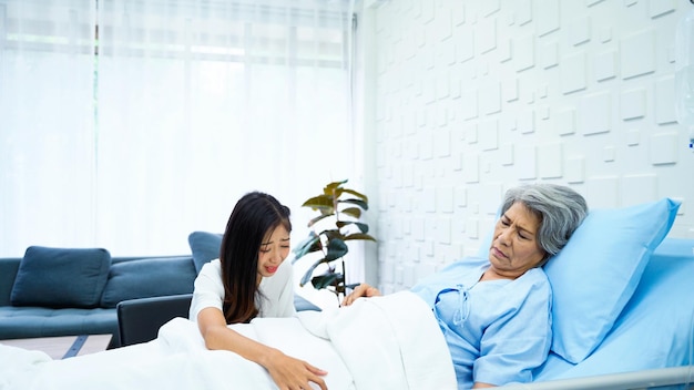 사진 노인 여성 환자는 환자의 방에 있는 침대에 의식이 없는 상태로 누워 있습니다.