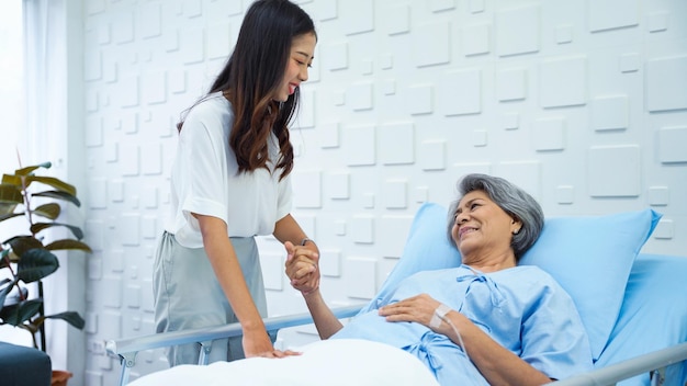 Elderly female patient lying in bed receiving saline solution in the patient room