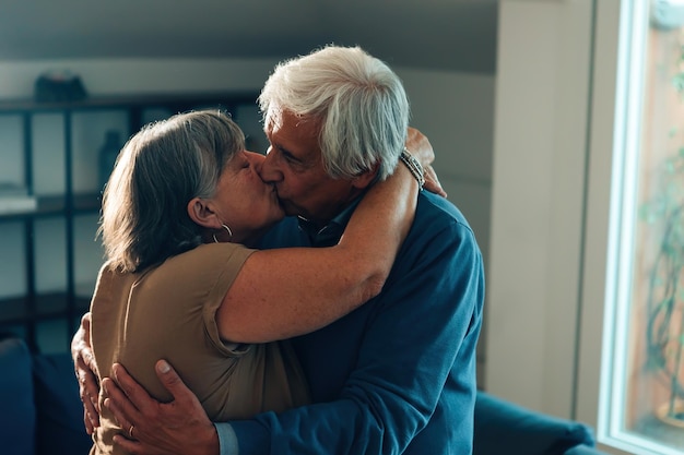 Фото Пожилая гетеросексуальная пара с седыми волосами целуется и обнимается дома