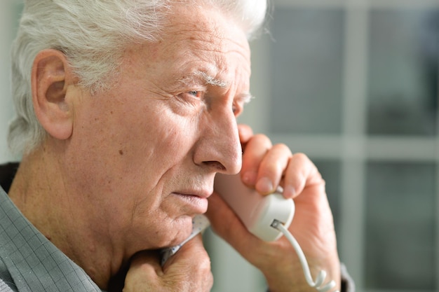 Elderly ill man calling doctor