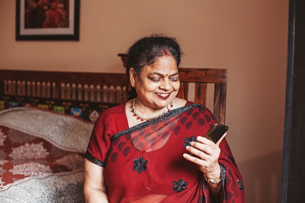 Elderly Indian woman using her phone to connect over video call