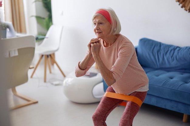 Elderly lady doing fitness workout at home