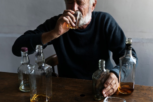 Photo elderly man drinking alcohol