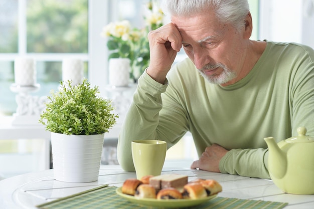 Elderly man drinking cup of coffee