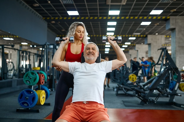 Elderly man, exercise with dumbbells on bench