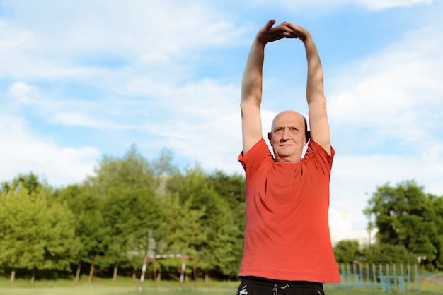 Elderly man do exercises in the Park. Active and healthy lifestyle.