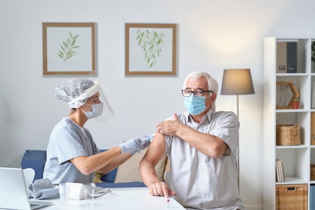 Elderly man getting vaccine from disease