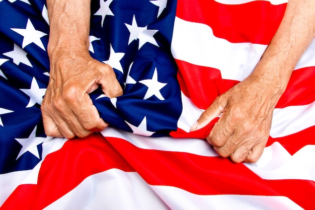 Foto mani dell'uomo anziano che tengono una bandiera degli stati uniti