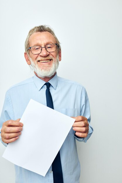 Elderly man holding documents with a sheet of paper light background