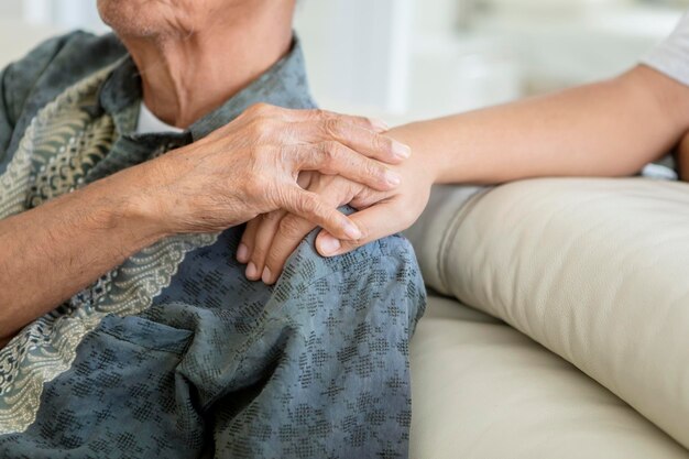 写真 家で息子と手をつないでいる年配の男性