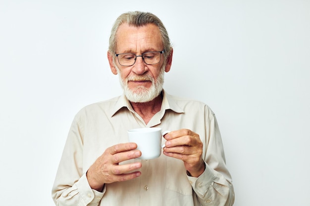 Elderly man holding a mug on a white background