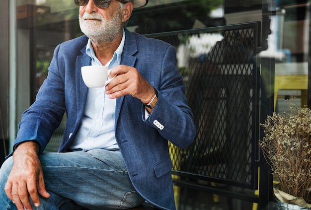 Elderly man is enjoying a coffee