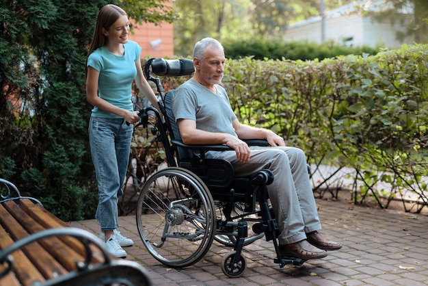 An elderly man is sitting in a wheelchair