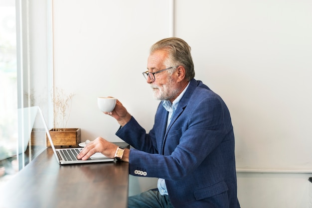 Elderly man is using computer laptop