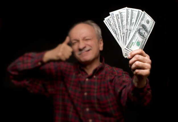 Elderly man showing fan of money