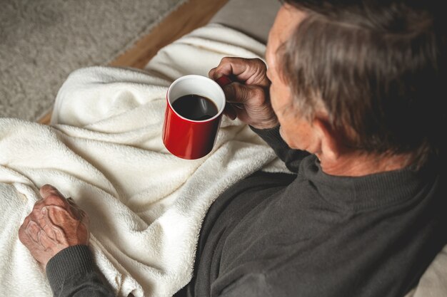 一杯のコーヒーを手に座っている老人