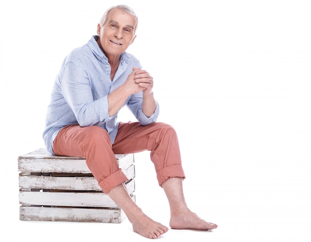 Elderly man sitting on the wooden box