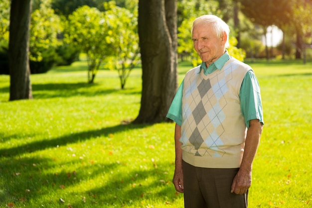 Elderly man standing outdoor.