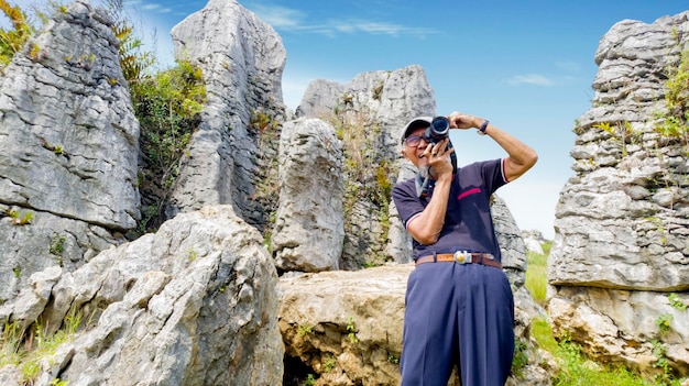 Elderly man taking a photo in Stone Garden site