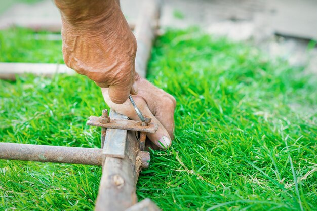 Elderly man twists the nut by wrench