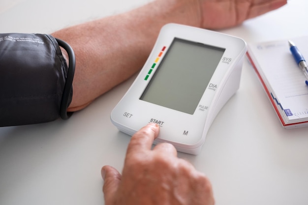 Elderly man using medical device to measure blood pressure senior man suffering from hypertension