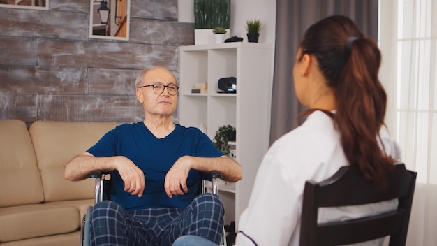 Elderly man in wheelchair with disability and medical worker. Disabled disability old person with medical worker in nursing care home assistance, healthcare and medicine service