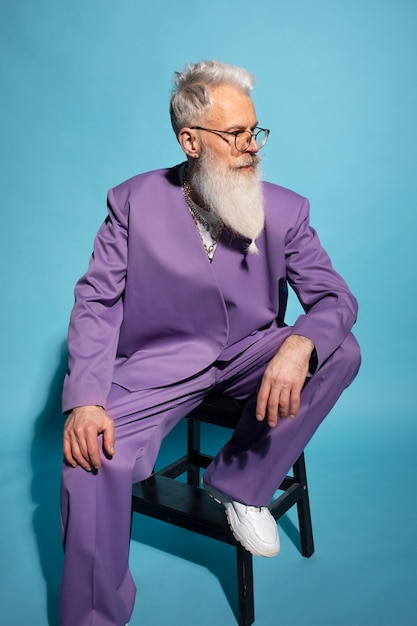 Elderly man with chain necklaces posing