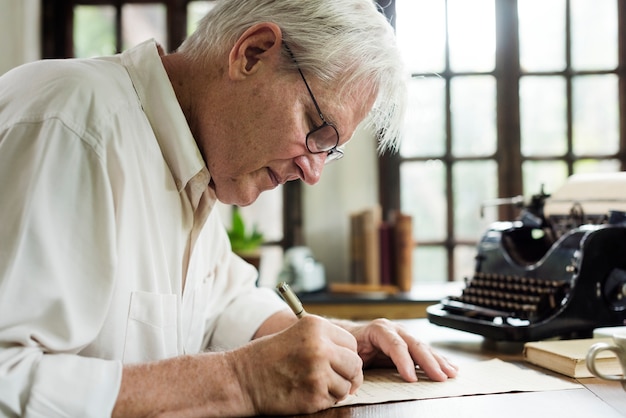 Photo elderly man writing a letter