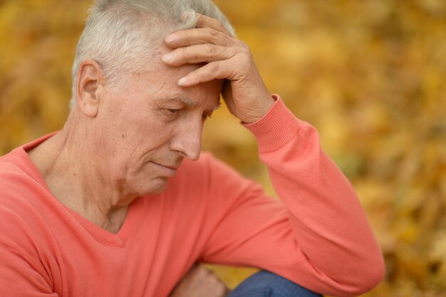 Elderly man on yellow autumn background close-up