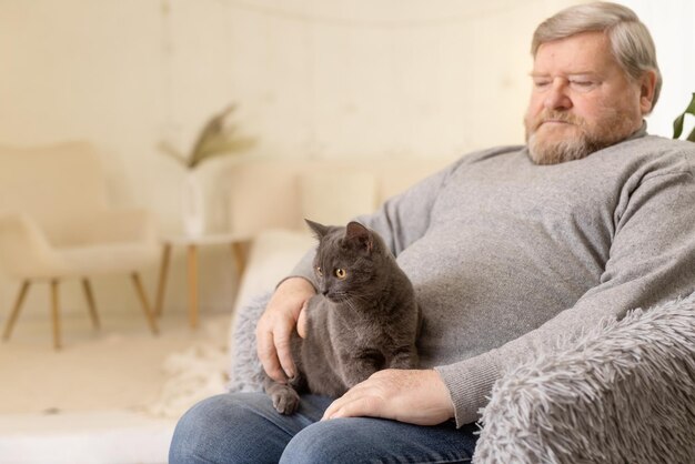 高齢者が猫の世話をして家で楽しむ