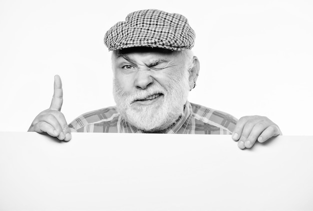 Elderly person Senior bearded emotional man peek out of banner place announcement Pensioner grandfather in vintage hat poster information copy space Announcement concept Event announcement