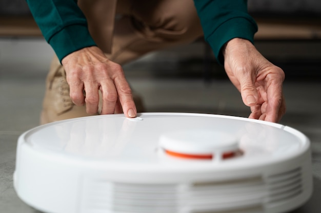 Elderly person using digital vacuum cleaner