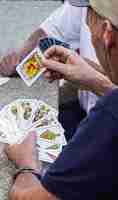 Photo elderly and retired people playing with a deck of spanish cards on a stone table in a village