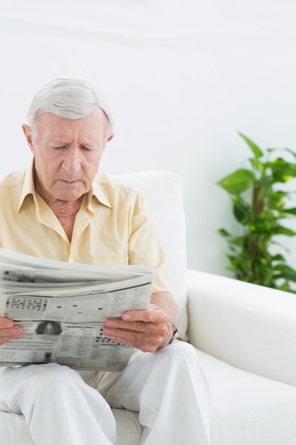 Elderly serious man reading newspapers 
