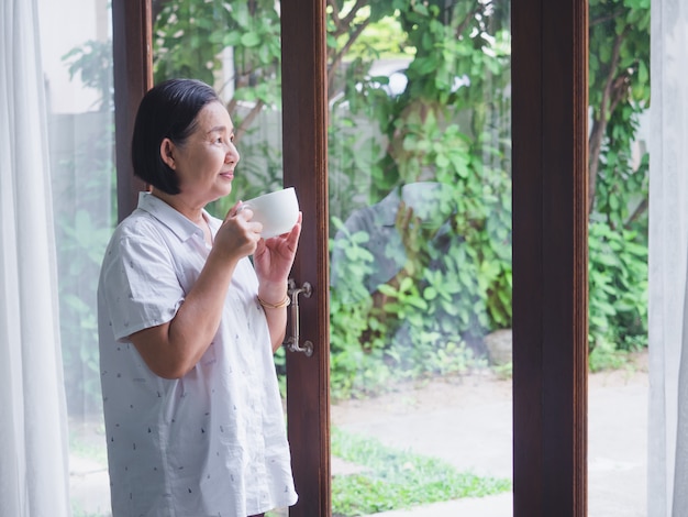 The elderly thinking something with drink coffee