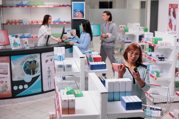 Foto donna anziana che analizza scatole e flaconi di medicinali in farmacia per acquistare un trattamento di prescrizione. guardando prodotti sanitari farmaceutici, farmacia piena di vitamine e farmaci.