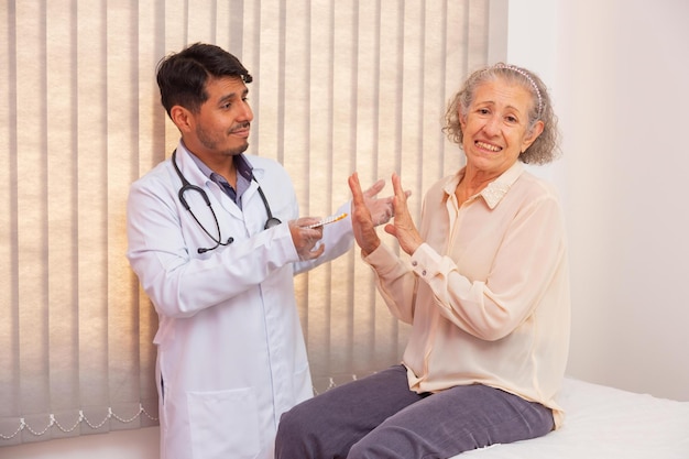 Elderly woman angry for having to take medicine. doctor trying
to convince the elderly woman to take medicine