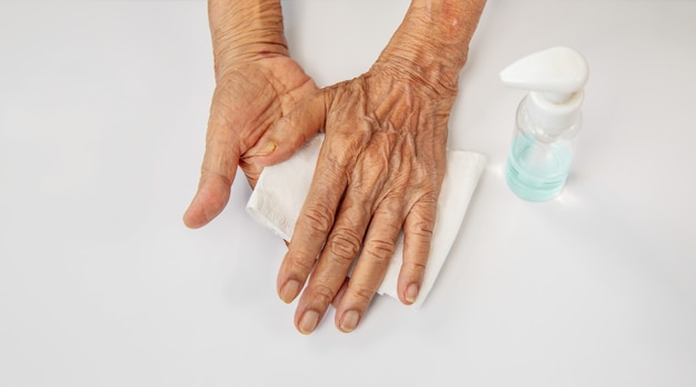 Elderly woman applying alcohol gel cleaning hands to helping protect from coronavirus covid-19