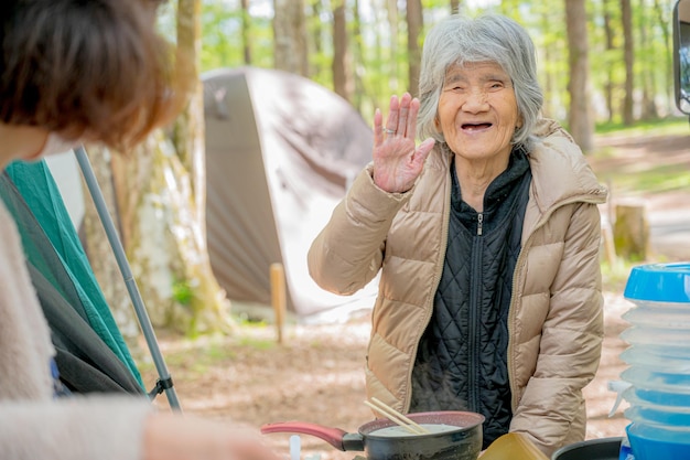 キャンプで料理をする年配の女性