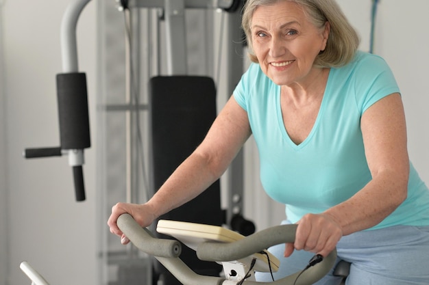 Elderly woman exercising in gym