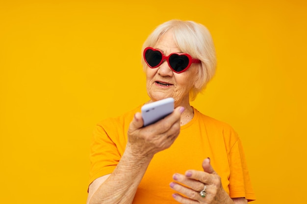 Elderly woman happy lifestyle in yellow tshirts glasses isolated background