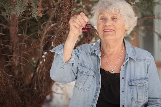 Photo elderly woman holding a bowl of ripe cherries