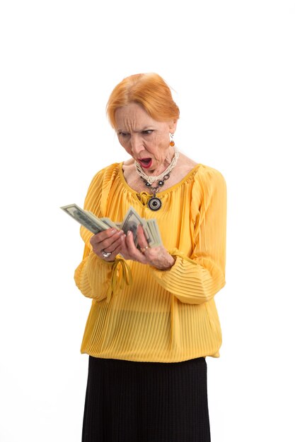 Photo elderly woman holding money isolated surprised lady looking at cash count the expenses