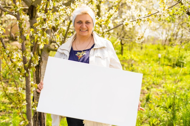 elderly woman holds a photo canvas.