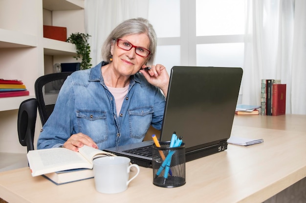 Elderly woman looks at smiling face sitting at a desk in front of a laptop