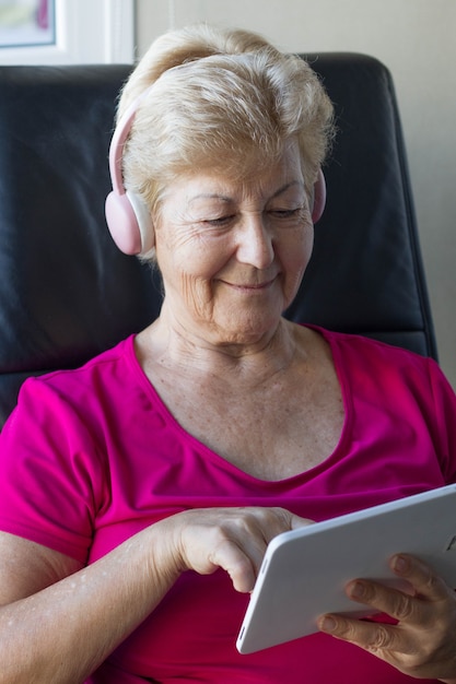 Photo elderly woman manipulating electronic devices for distraction and information