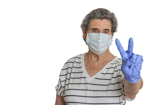 Elderly woman in medical mask gesturing V sign